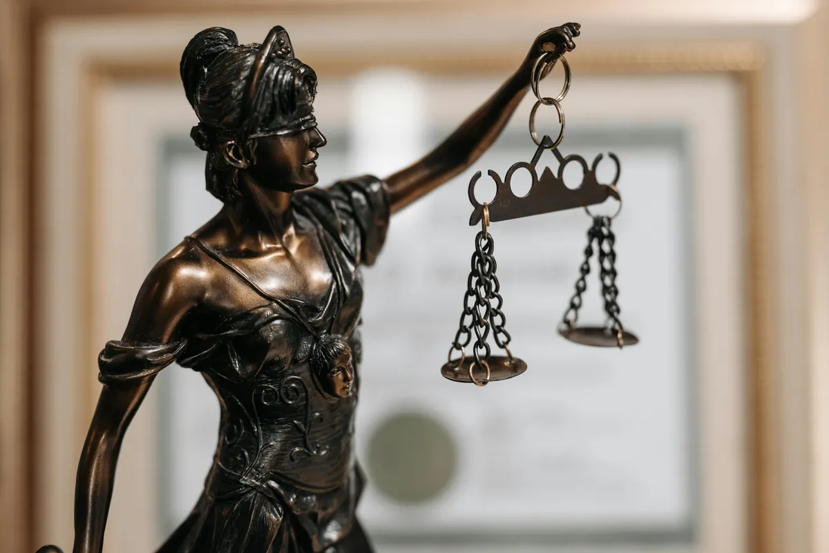 Statua della Giustizia con bilancia, simbolo del diritto civile e penale